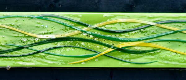 This is a fused glass wall art panel in greens.